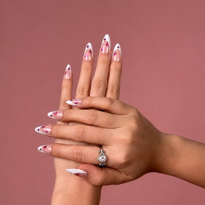 Starlet press-on nails, pink and white French tips scattered with magenta sparkle stars